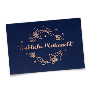 Vergrößere Abbildung Dunkelblaue Weihnachtskarte mit kupfergoldenem Gruß 'Fröhliche Weihnacht' im floralen Kranz.